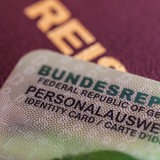 Ein Personalausweis liegt auf einem Reisepass.