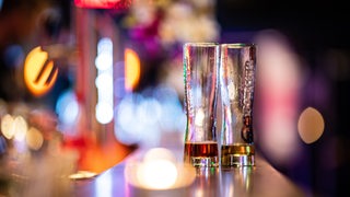 Zwei leere Bier-Gläser stehen auf dem Tresen einer Bar. 