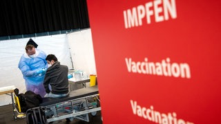 Ein Mann wird im Bremer Impfzentrum geimpft.