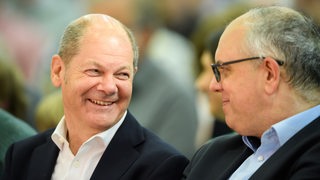 Olaf Scholz und Andreas Bovenschulte unterhalten sich 2019 bei einer SPD-Veranstaltung in Bremen.