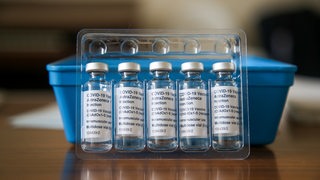 Impfdosen von AstraZeneca stehen auf einem Tisch.