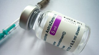 Ein Fläschen des Impfstoffs von AstraZeneca mit einer Kanüle.