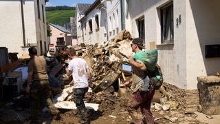 Helfer arbeiten in den Straßen von Dernau. Das Hochwasser hat hier zahlreiche Häuser unbewohnbar gemacht.