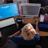 Eine KI-Wissenschaftlerin des Landeskriminalamt Niedersachsen arbeitet an Computerbildschirmen und programmiert Lösungen mit Künstlicher Intelligenz zum Auffinden von zum Beispiel kinderpornografischen Inhalten im Internet. 