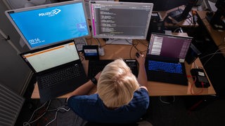 Eine KI-Wissenschaftlerin des Landeskriminalamt Niedersachsen arbeitet an Computerbildschirmen und programmiert Lösungen mit Künstlicher Intelligenz zum Auffinden von zum Beispiel kinderpornografischen Inhalten im Internet. 