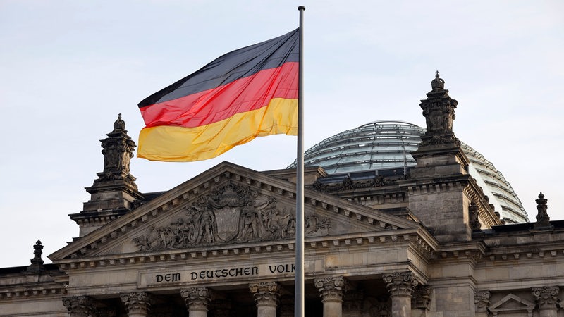 Die Deutschlandflagge weht vor dem Reichstag in Berlin