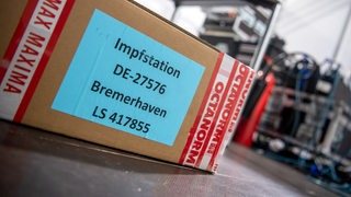 "Impfstation Bremerhaven" steht auf einem Karton mit Materialien für das Corona-Impfzentrum. 