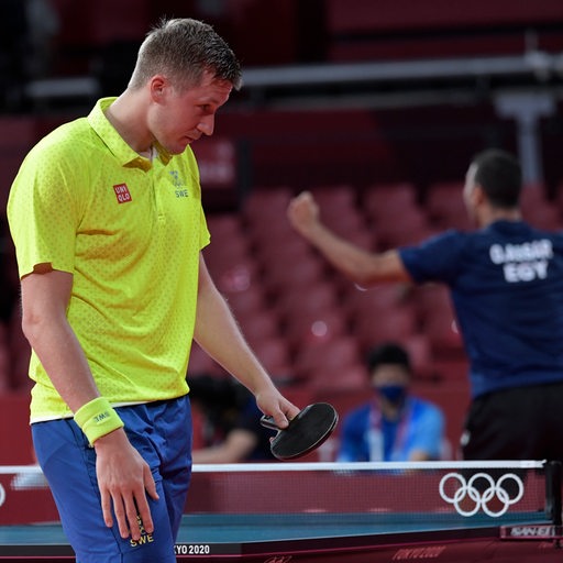 Tischtennis-Profi Mattias Falck mit hängendem Kopf, während sein Gegner Omar Assar jubelnd hinter ihm hochspringt.