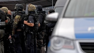SEK-Beamte der Bremer Polizei stehen vor einem Gebäude für einen Einsatz bereit.
