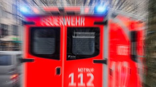 Ein Rettungswagen der Feuerwehr fährt mit Blaulicht.