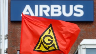 Eine Fahne der IG Metall vor einem Airbus-Gebäude