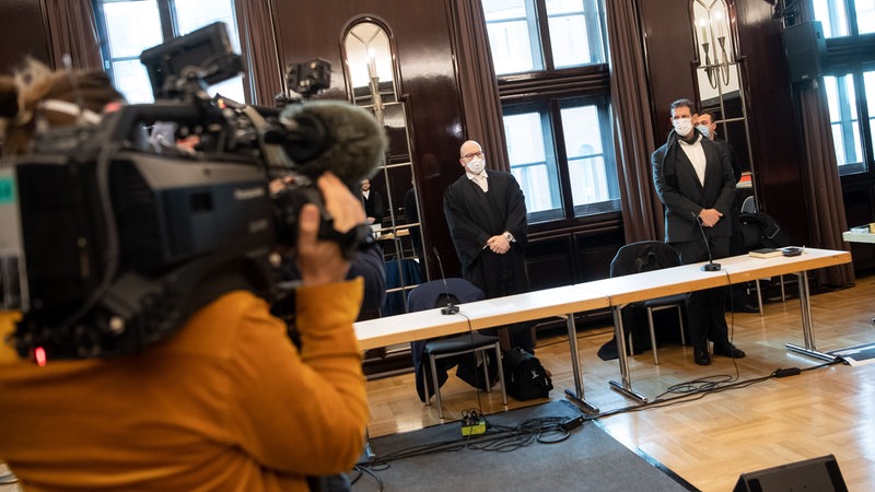 Kamerateams filmen den Angeklagten, Pastor Olaf Latzel (r), und seinen Anwalt Sascha Böttner (2.v.r) im Gerichtssaal stehend.
