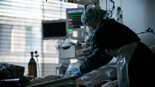 Eine Krankenschwester behandelt auf der Intensivstation einen Patienten mit Covid 19