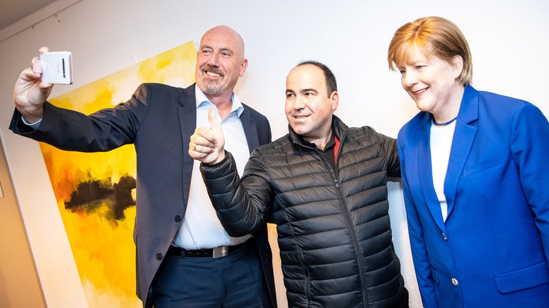 Merkel-Fan Alexis Vaiou (M) und Carsten Meyer-Heder (l), Landesvorsitzender der CDU Bremen, machen ein Selfie mit der lebensgroßen Wachsfigur von Bundeskanzlerin A. Merkel in der CDU-Zentrale. 
