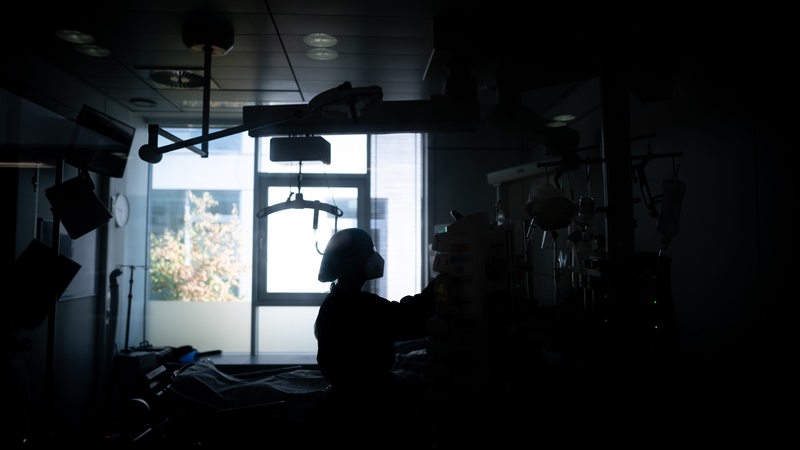 Eine Mitarbeiterin der Pflege steht in einem Patientenzimmer auf der Corona-Intensivstation des Universitätsklinikums Essen.