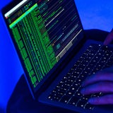 Eine Person hat einen Laptop auf den Beinen und wertet Daten aus.