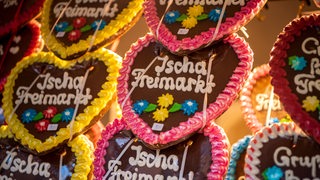 Lebkuchenherzen mit der Aufschrift "Ischa Freimarkt" hängen an einem Stand.