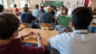 Schülerinnen und Schüler sitzen in einem Klassenzimmer.
