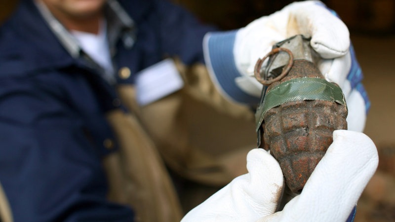 Ein Mitarbeiter des niedersächsischen Kampfmittelräumdienstes zeigt eine amerikanische Handgranate aus dem 2. Weltkrieg. 
