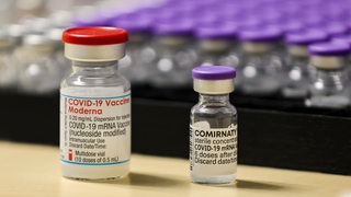 Impfstoff-Ampullen von Moderna (links) und Biontech stehen nebeneinander.