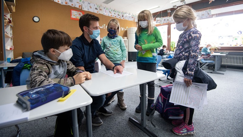 Grundschüler mit Maske in einem Klassenzimmer.