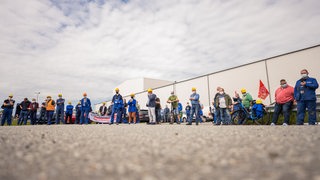 Mitarbeiter der Meyer-Werft sind während ihrer Betriebsversammlung vor den Toren der Werft auf einem Parkplatz versammelt.