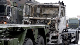 Die Zugmaschine eines Bundeswehrfahrzeuges steht ausgebrannt auf dem Gelände einer Nutzfahrzeugfirma.
