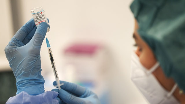 Eine Pharmazeutin zieht im Impfzentrum für Fußgänger und Radfahrer eine Spritze mit dem Impfstoff von Moderna auf.
