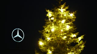 in Mercedes-Stern ist neben einem Weihnachtsbaum zu sehen.