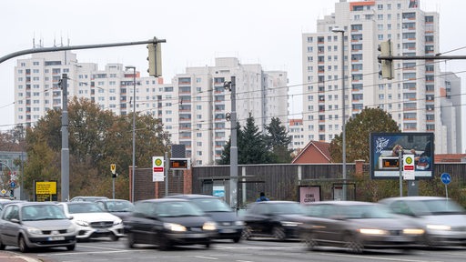 Autos fahren an den Hochhäusern im Bremer Stadtteil Tenever vorbei.