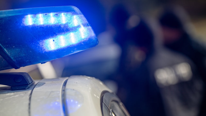 Das Blaulicht eines Polizeiautos blinkt.