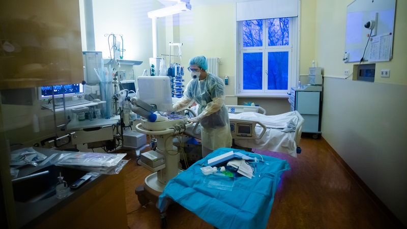 Eine Assistenzärztin betreut auf der Intensivstation eines Krankenhauses einen Covid-19-Patienten.