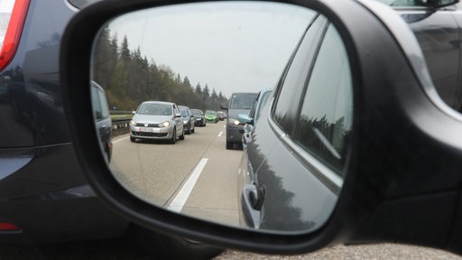 Auf einer Autobahn herrscht großes Verkehrsaufkommen mit teilweise stockendem bis stehendem Verkehr.