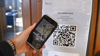 Einchecken mit der Luca App. Hinweisschild mit Informationen zur Schnellregistrierung mit der LUCA App an der Eingangstuer an einem Restaurant