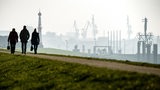 Spaziergänger laufen über den Deich in Bremerhaven