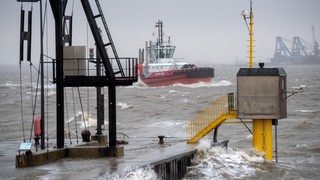 Ein Schiff fährt während der Sturmflut durch den Hafen von Bremerhaven