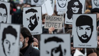 Schilder mit den Gesichtern der Terror-Opfer von Hanau