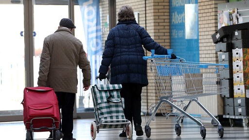 Ältere Menschen auf dem Weg zum Supermarkt. 