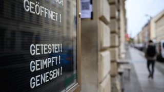 "Getest! Geimpft! Genesen!" steht auf einem Schild an einer Bar