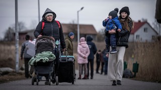 Geflüchtete aus der Ukraine kommen nach ihrem Grenzübertritt von Schehyni in der Ukraine nach Medyka in Polen.