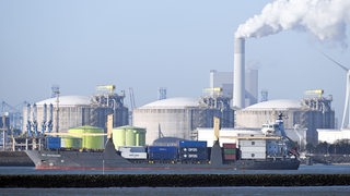 Ein Schiff fährt vor einem LNG-Terminal im Hafen von Rotterdam entlang.