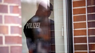 Ein Polizist steht in einem Gebäude im Stadtteil Hemelingen. 