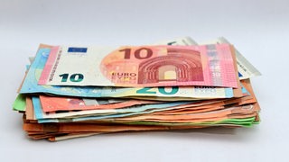 Ein Stapel mit Bargeld liegt auf einem Tisch.