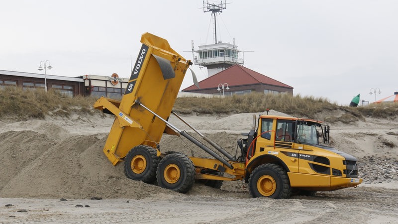 Ein Muldenkipper, ein sogenannter Dumper, schüttet am Badestrand von Wangerooge Sand aus einem Reservoir im Osten der Insel auf. Am Dienstag begannen die Arbeiten zur Wiederherstellung des für den Inseltourismus wichtigen Strandes. 