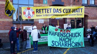 Demonstranten  mit Platen vor einem Gebäude