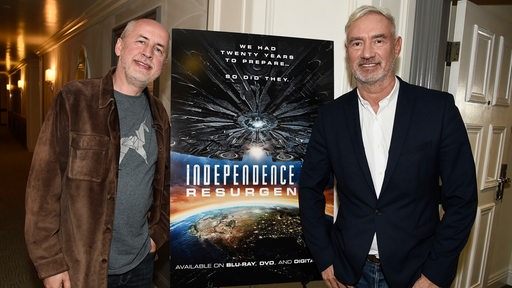 Zwei Männer stehen neben einem Plakat mit der Aufschrift "Independence Resurgence".