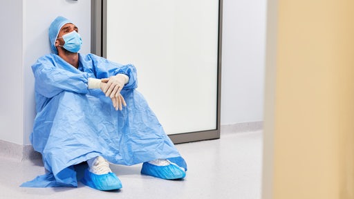 Erschöpfter Arzt macht Pause vor der Intensivstation