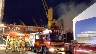 Einsatzkräfte der Feuerwehr Bremerhaven sind bei Löscharbeiten bei einem Brand auf einem Frachter. 