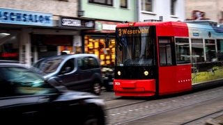 Eine Straßenbahn der Linie 3 fährt zwischen Autos durch die Innenstadt von Bremen.