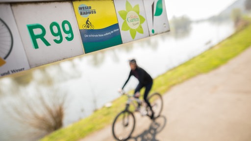 Ein Fahrradfahrer fährt auf dem Weser-Radweg